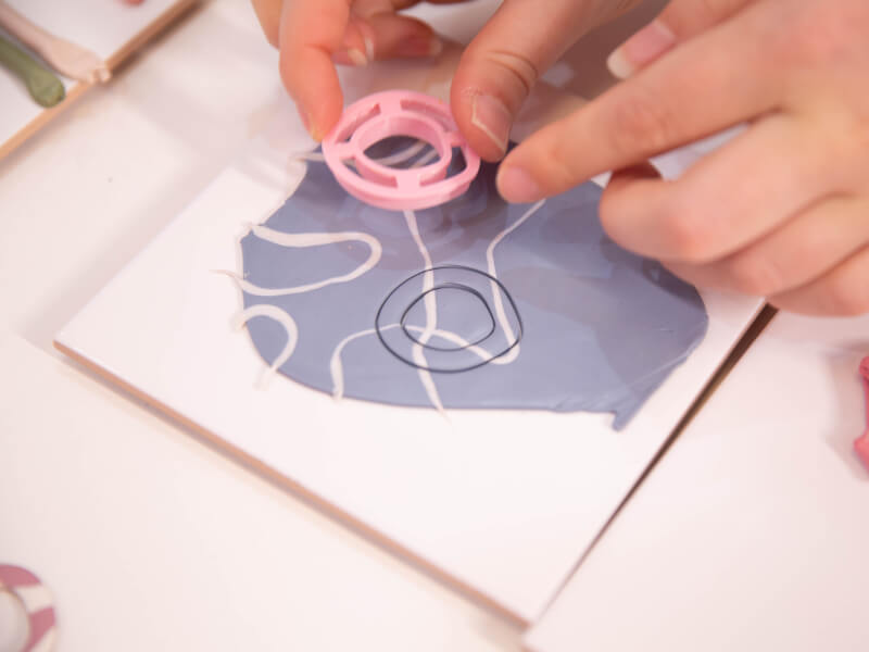 Person using mould to cut out polymer clay